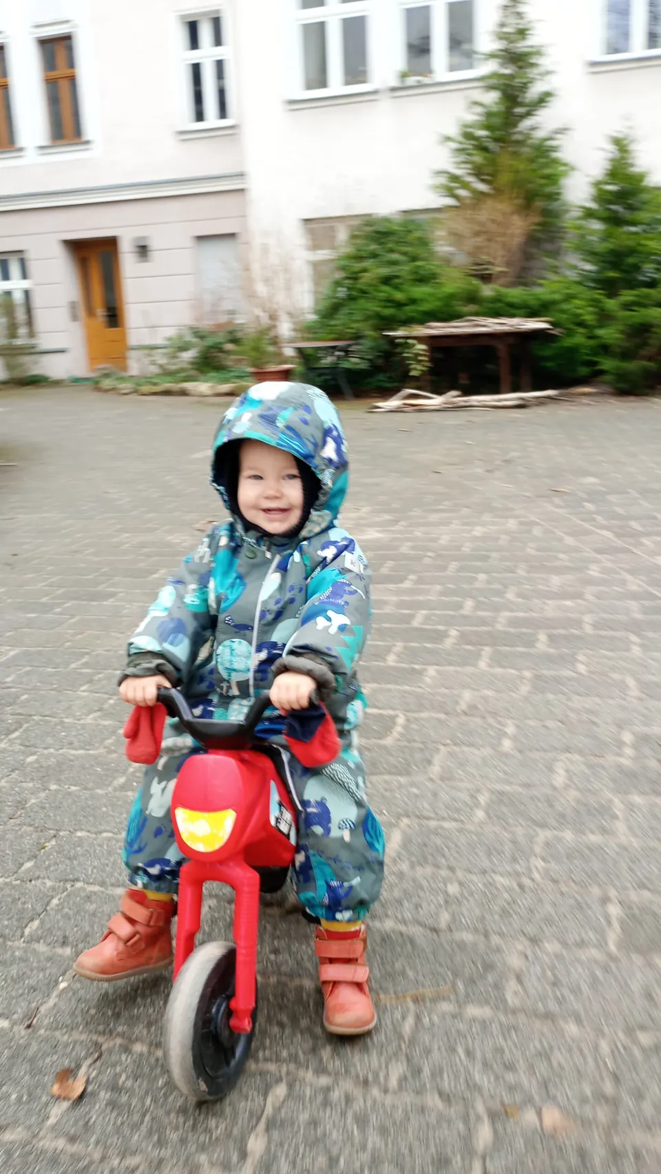 Ein Kind fährt auf einem roten Laufrad
